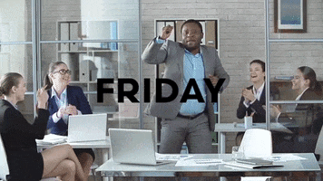 Video gif. Man in a suit shimmies in front of his desk as female coworkers cheer him on from the side. Text, "Friday."