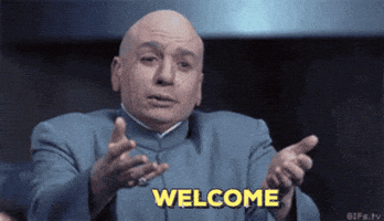 Movie gif. Mike Myers as Dr. Evil from Austin Powers reaches out his arms, as if to welcome someone into a hug. Text, "Welcome."