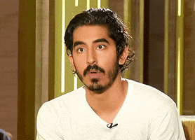 Celebrity gif. Dev Patel raises his eyebrows and sits up straighter while nodding and saying, "yep."