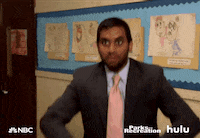 Parks and Recreation gif. digital download - Aziz Ansari as Tom looks at someone off screen and throws a bunch of dollar bills into the air. 