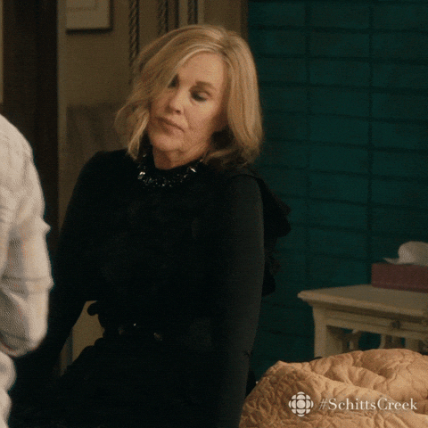 Schitt’s Creek gif. Giving up, a dramatic Catherine O'Hara as Moira rolls her eyes and falls back on her bed.