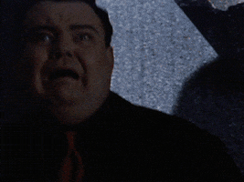 Movie gif. Eyes wide in fear, Glenn Shadix as Otho from Beetlejuice screams and helplessly presses his back against a wall.