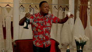 TV gif. Lamorne Morris as Winston in New Girl dancing in a bridal shop holding a bottle and a glassful of champagne with his eyes closed.