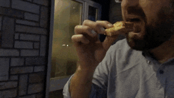 Music video gif. From video for Kanye's "Famous," Eric Wareheim takes a dainty bite of food, leans back and spins around on a sidewalk under a flickering light.