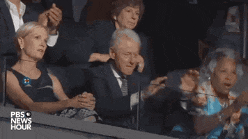 Political gif. Bill Clinton stands in applause giving Bernie Sanders a standing ovation. 