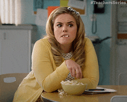 TV gif. Kate Lambert as Caroline in Teachers munches on a bowl of popcorn as she furrows her brow and slowly rolls her eyes.