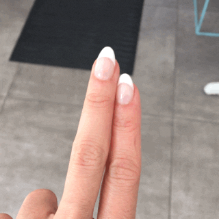 Video gif. A hand with a French manicure shows us their fingers straight, then crosses their fingers and turns them around, palm up.