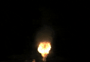 Video gif. A plume of fire and smoke flies up and disappears as it comes down.