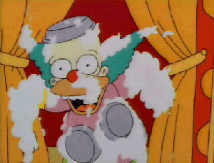 Krusty the Clown laughs covered in creamy pie tins.