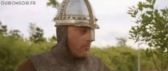 Video gif. A man in a medieval helmet and chainmail angrily says, “Silence manente ou tu va prendre une cla-claque!”