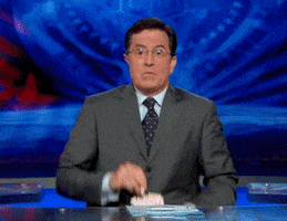 Celebrity gif. A riveted Stephen Colbert sits wide-eyed, eating popcorn as if deeply entertained.