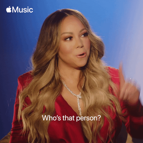 Celebrity gif. Mariah Carey pointing up to the right and saying, "who's that person?"