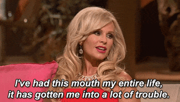 Reality TV gif. Tamra Judge on Real Housewives of Orange County. She's sitting on a couch and she looks around and tells us, "I've had this mouth my entire life, it's gotten me into a lot of trouble."