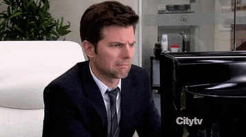 Parks and Recreation gif. Adam Scott as Ben Wyatt startled by something on the computer, making a disgusted face.