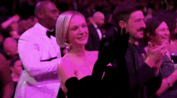 Oscars 2024 GIF. Carey Mulligan, claps happily, taking in the performance.