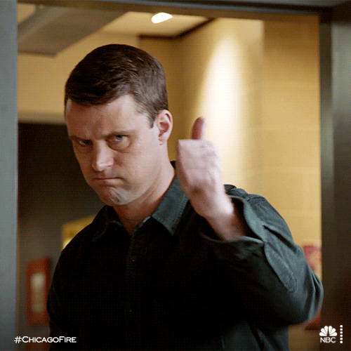 TV gif. Jesse Spencer as Matthew in Chicago Fire. He puffs his cheeks out and looks up awkwardly before sending us a thumbs up and backing away. 