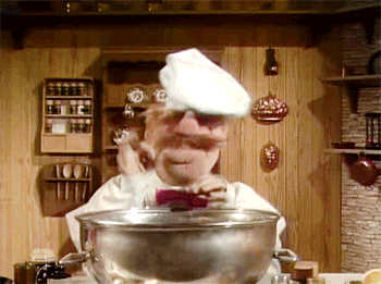 Muppet chef throws ingredients into a bowl. 
