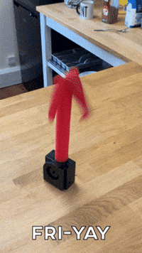 Video gif. A tiny inflatable tube man sits on a table flailing around erratically. The camera pans over to a real man copying the tube man’s movements, flailing his arms and body around.