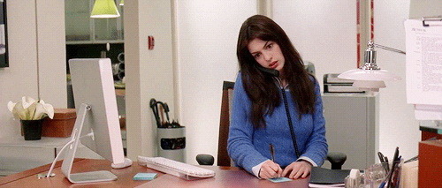 Andrea (Anne Hathaway) respondiendo el telefono de la oficina