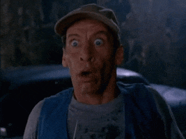 Movie gif. Jim Varney as Ernest P. Worrell steps back towards a car with a fearful expression on his face. His eyes are wide with fear and his mouth is open in shock.