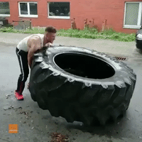Impressively Strong Man Continuously Flips Giant Tire Along Road