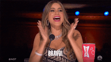 Reality TV gif. Sofia Vergara on America’s Got Talent claps enthusiastically. Text, “Bravo!”