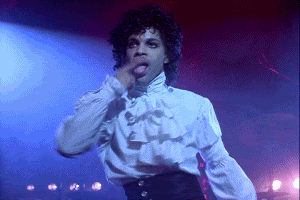 Celebrity gif Prince dances onstage licking his finger and then smoothing back his curly hair