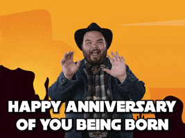 Celebrity gif. Howdy Price, dressed in a plaid flannel, denim jacket, and black cowboy hat, smiles and holds his hands out toward us, saying, "Happy anniversary of you being born," which appears as text.
