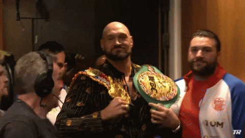 GIF showing a boxer raising a championship belt, symbolizing victory and high rankings in the competitive world of college football, relevant to the Clemson vs LSU matchup.