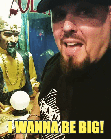 Celebrity gif. Pro Wrestler Brimstone looks at us, nodding in excitement as he says, “I wanna be big!”. He hurriedly turns to put a quarter into a Zoltar machine. 