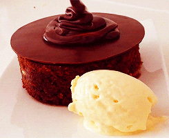 bolo em espanhol
DESCRIÇÃO DA IMAGEM: Alguém está colocando calda em cima de um bolo de chocolate. Ao lado, temos uma bola de sorvete de creme.