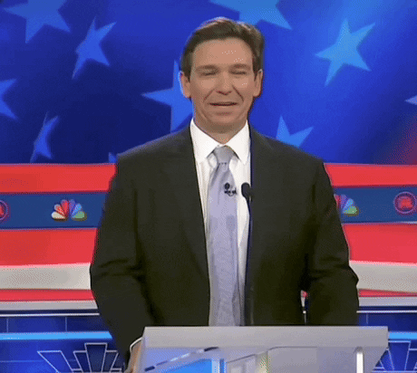 Video gif. Ron DeSantis stands at a podium during a presidential debate. He laughs to himself then looks to the side with an uncomfortable, somewhat uncertain expression. Subtitle text reads, "That's not true." 
