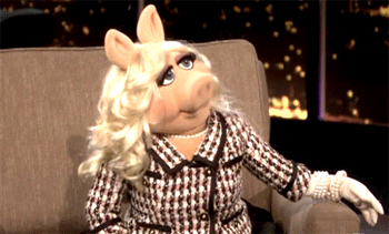 Celebrity gif. Miss Piggy sits in a chair at an interview. She looks up, shaking her head as she says, “No.”