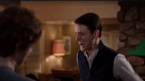 TV gif. Zach Woods as Jared in Silicon Valley. He's pumped up and eagerly throws both arms up in the air while yelping. He stares at his friend and his face is flushed with excitement.