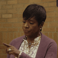 TV gif. Sheryl Lee Ralph as Barbara in Abbott Elementary purses her lips and nods as she points to the side.