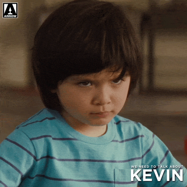 Movie gif. Rock Duer, as toddler Kevin in We Need to Talk About Kevin, glaring unhappily at something.