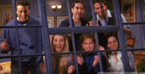 Friends gif. Matt Leblanc, Lisa Kudrow, David Schwimmer, Jennifer Aniston, Matthew Perry, and Courteney Cox as their characters on Friends happily applaud someone through large steel blue windows that looks into their cozy space.