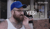 TV gif. In a "man on the street" interview, a bearded man with glasses, wearing a sleeveless white shirt and a blank blue cap, emphatically agrees. Text follows his hand as he punctuates his speech: "Yes!"