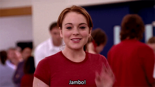 Movie gif. Lindsay Lohan, as Cady in Mean Girls gives us a friendly wave and says, “Jambo!”