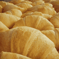 Sponsored gif. The Pillsbury Doughboy, in his iconic blue scarf and Pillsbury chef hat, pops up in front of an image of crescent rolls. Text: "Turkey Time" 