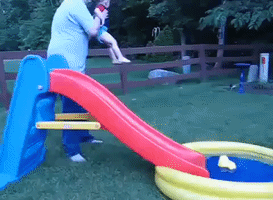 Infant Zips Into Pool On A Fast Slide