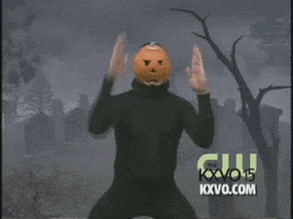 Meme gif. A man dressed in all black and a jack o lantern mask squats in the middle of a spooky graveyard. The jack o lantern man looks at us with a blank jack o lantern stare and moves his hands in straight motions like he’s creating a box around his face.  