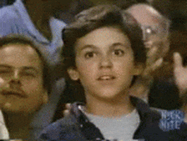 TV gif. Among an applauding crowd, Fred Savage as Kevin in The Wonder Years looks out at us, proud and raising up a thumbs up.