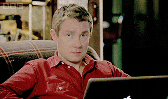 TV gif. Martin Freeman as Watson on Sherlock sits in a recliner with a laptop on his lap. He looks up from his screen in complete shock and then he looks down at it again with confusion. He looks away from it again now concerned. 