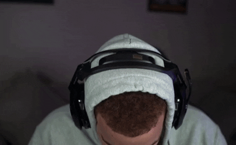 Video gif. A man wearing headphones and playing video games looks at us and says, “Damn that’s crazy bro.”