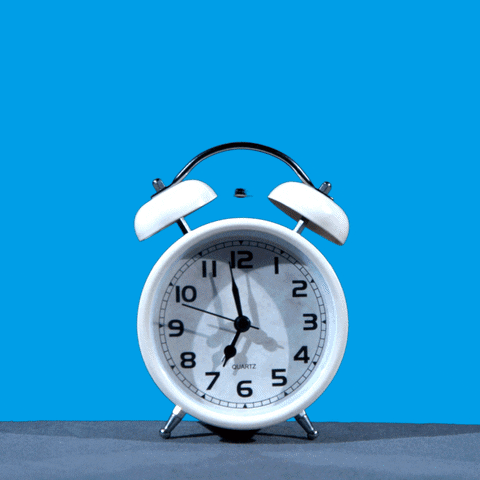 Illustrated gif. Classic alarm clock radiating sound waves on a sky blue background, before a hand comes in and smashes it to stop. Text, "Wake up, vote early!"