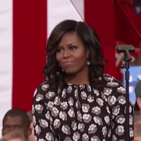 Political gif. Michelle Obama looks down as she lifts her hands up over her head and claps delicately.