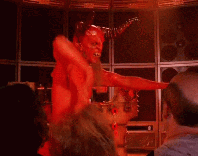 Video gif. A red devil character with ram horns does the booty slap with a pelvic thrust and one arm slapping back and forth.