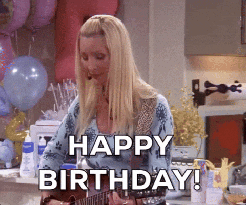 Friends gif. Lisa Kudrow as Phoebe bounces and looks around as she plays her guitar in a room full of balloons. She happily sings, “Happy Birthday!”