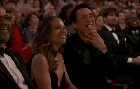 Oscars 2024 GIF. Susan and Robert Downey Junior, seated at the Oscars, Robert pointing at the performer as they privately enjoy the moment together.